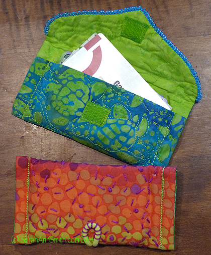 The blue-green card holder has velcro closing.  I painted white velcro with acrylic ink to match.  The warm-tones uses that thick hair elastic.  I like the way I used perle cotton to quilt the bag and stitch down the back end of the hair elastic. 